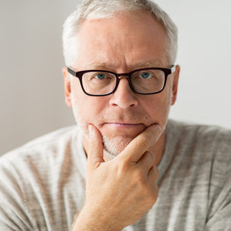 close up of senior man in glasses thinking